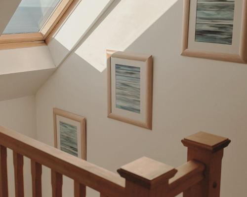 a staircase with three pictures on the wall at Honeysuckle Cottage in Killean