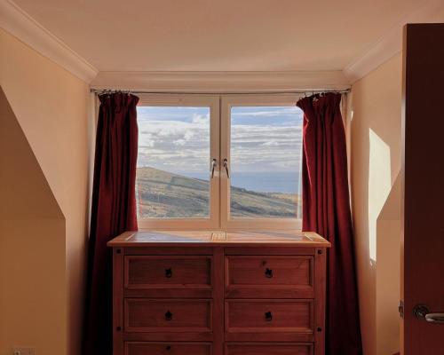 a window in a room with a dresser with a view at Honeysuckle Cottage in Killean