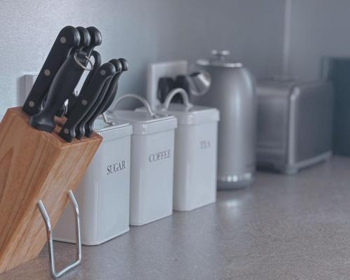 a knife block with a bunch of knives in it at Honeysuckle Cottage in Killean
