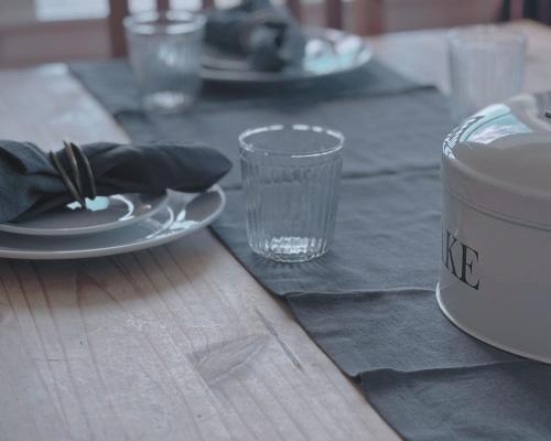 a wooden table with a plate and a glass on it at Honeysuckle Cottage in Killean