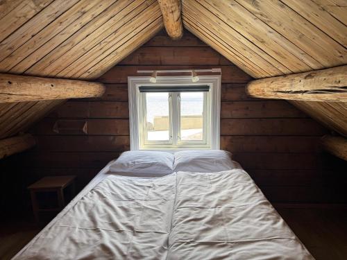 a bed in a wooden room with a window at Toppøy Rorbuer in Reine