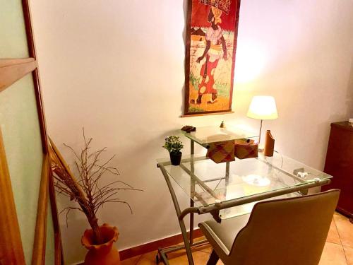 a room with a glass desk with a lamp and a painting at Terrasse sur l'océan in Tarrafal
