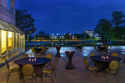 a patio with tables and chairs at night at Sheraton Suites Chicago Elk Grove in Elk Grove Village