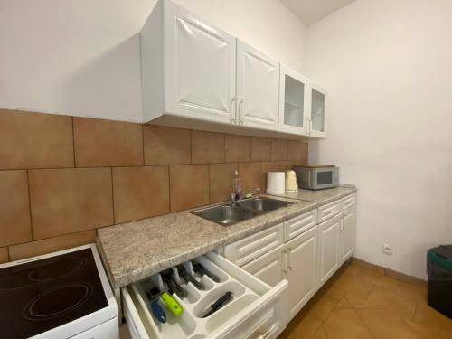 a kitchen with white cabinets and a sink at Apartmány Pražská in Ústí nad Labem
