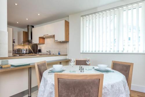 een keuken met een tafel en stoelen in een kamer bij Peregrine - Poole Quay Location with Partial Harbour Views in Poole