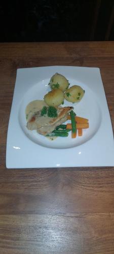 a plate of food with potatoes and vegetables on a table at Paradise Itzu in Kandy