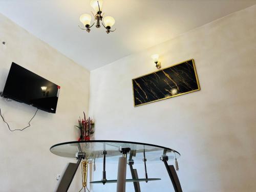 a dining room with a glass table and a tv at HOTEL MAA MEVFOU Hmm in Yaoundé