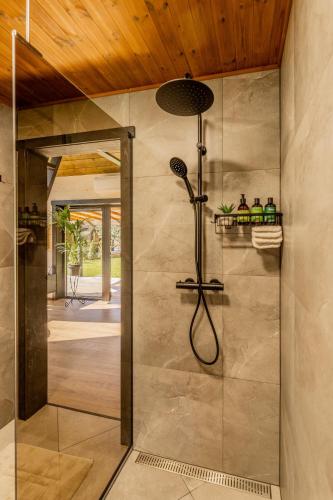 a shower with a glass door in a bathroom at Tindioru Tower Resort in Nogo