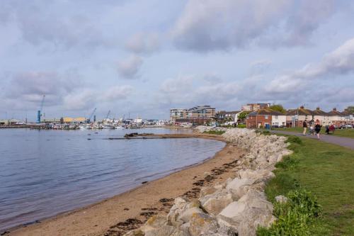 people walking along the shore of a body of water at Anchorage - Quaint and Cosy Two-Bedroom House in Poole