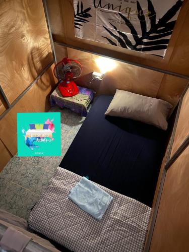 a small room with a bed and a pillow at HostelBed and Art Space Phichai in Phichai