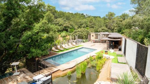 an overhead view of a swimming pool with a patio and trees at Charming villa in the heart of the Mediterranean Garrigue in Nîmes
