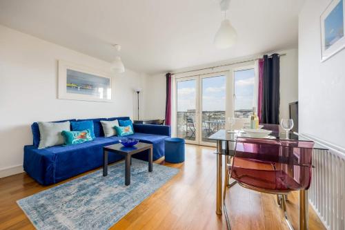 a living room with a blue couch and a table at Azure Views - Central Town Location, Minutes from Poole Quay in Poole