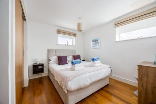 a white bedroom with a bed and two windows at Azure Views - Central Town Location, Minutes from Poole Quay in Poole