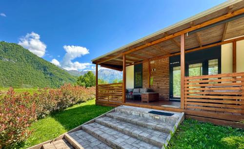 a wooden house with a patio and a lawn at Hiša Uran in Kobarid
