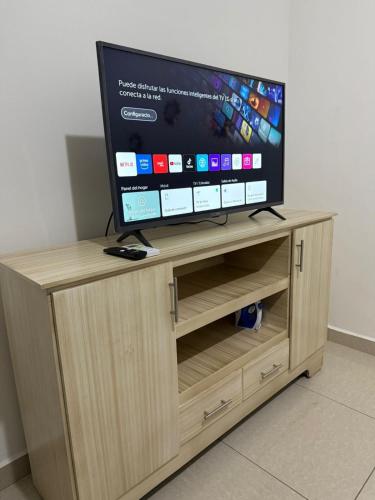 a flat screen tv sitting on top of a wooden entertainment center at House in Santa Rosa de Copan Residencial Palmira in Santa Rosa de Copán