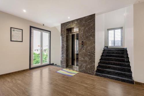 Habitación con escalera y pared de piedra. en Treebo Iraa, en Kākināda
