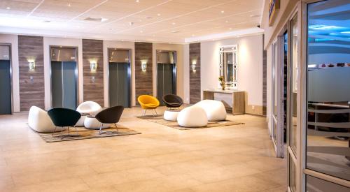 a lobby with chairs and tables in a building at Garden Court South Beach in Durban