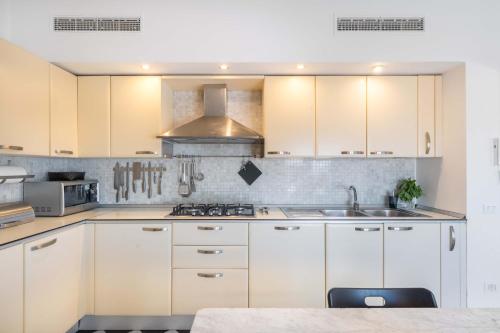a kitchen with white cabinets and a sink at AMORE RENTALS - The Roof in Sorrento