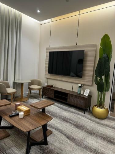 a living room with a flat screen tv on a wall at شقة فندقية من غرفة و صالة مع بالكونة مطلة in Jeddah