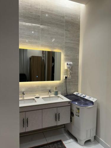 a bathroom with a sink and a mirror at شقة فندقية من غرفة و صالة مع بالكونة مطلة in Jeddah