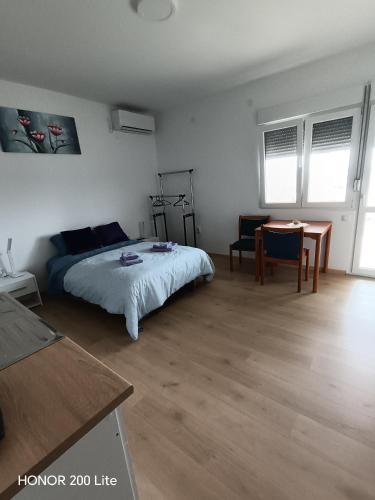 a bedroom with a bed and a table in it at Udobna Soba Sa Prelepim Pogledom #4 in Mladenovac
