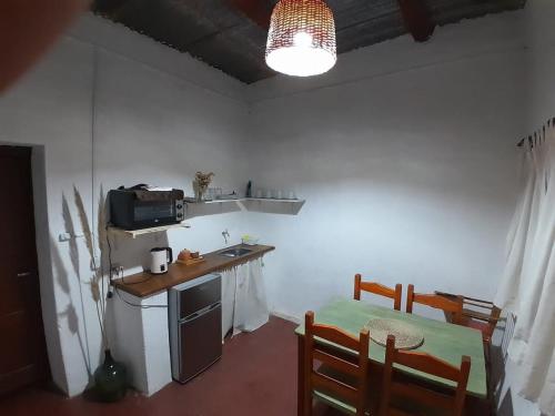 a kitchen with a sink and a table with a microwave at Casa La Candelaria in Tilcara
