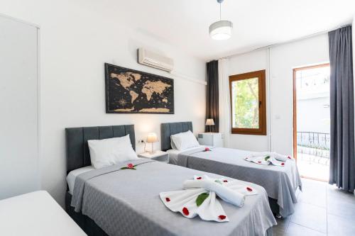 two beds in a room with white walls at Garden Bloom Hotel in Dalyan