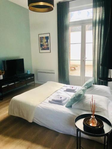 une chambre avec un grand lit et une fenêtre dans l'établissement Maison Gabriel Appartement LUNE, à Abbeville