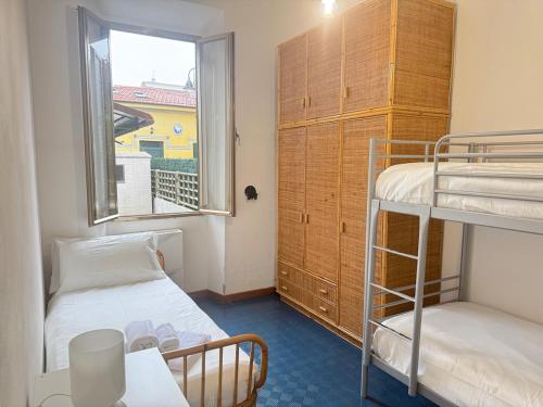 une chambre avec deux lits superposés et une fenêtre dans l'établissement 50mt from sea Villetta White 2 bedr outdoor, à Marina di Pietrasanta