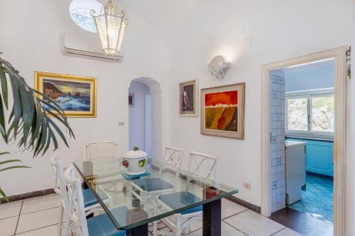 a dining room with a glass table and chairs at La Perla Marina Suite in Capri