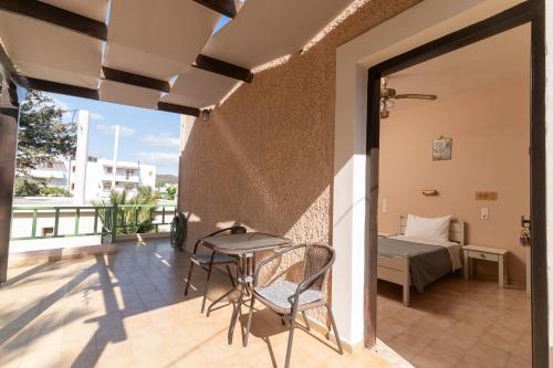 a balcony with a table and chairs and a bed at Filia Rooms in Matala