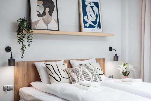 two white beds in a room with pictures on the wall at Nowy Hotel Monika - by Upstairs in Kraków