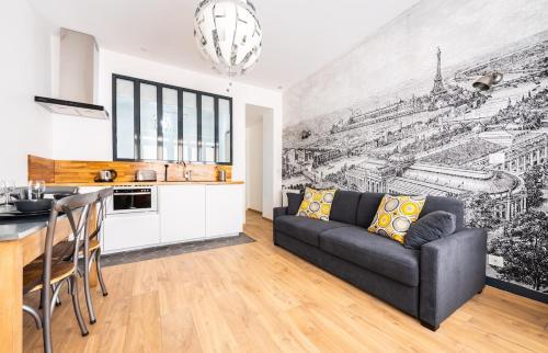 un salon avec un canapé noir et une cuisine dans l'établissement Wonderful flat Montparnasse, à Paris