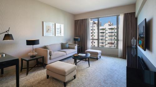 a living room with a couch and a tv at Marco Polo Xiamen in Xiamen