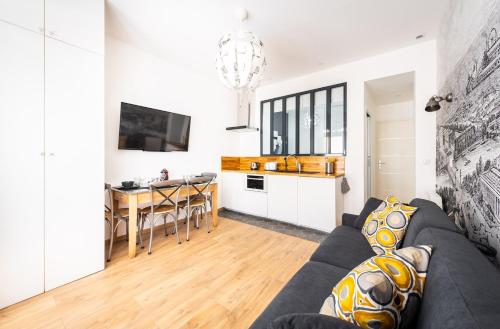 un salon avec un canapé et une table et une cuisine dans l'établissement Wonderful flat Montparnasse, à Paris