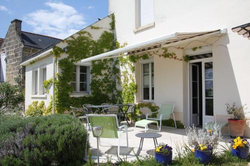 a patio with chairs and tables in front of a house at Doué's Mansion in Doué-la-Fontaine