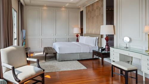 a bedroom with a bed and a desk and chair at Marco Polo Xiamen in Xiamen