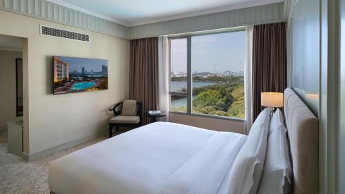 a hotel room with a bed and a large window at Marco Polo Xiamen in Xiamen
