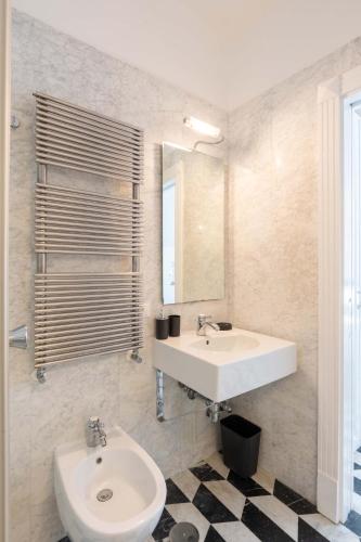 a white bathroom with a sink and a mirror at AMORE RENTALS - The Roof in Sorrento