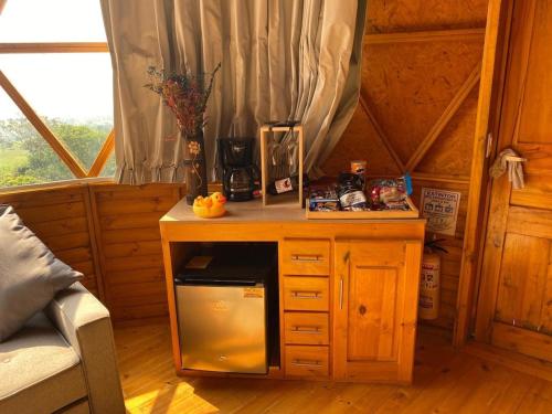 a small wooden table with a microwave in a room at Nido Acacias Cabaña espectacular Colibrí in Acacías