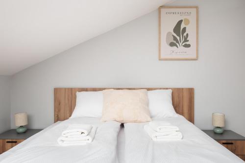 a bedroom with a white bed with two towels on it at Nowy Hotel Monika - by Upstairs in Kraków