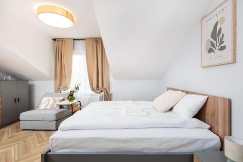 a bedroom with a large white bed and a chair at Nowy Hotel Monika - by Upstairs in Kraków