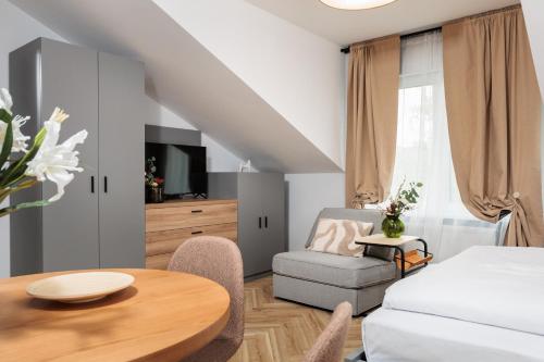 a bedroom with a bed and a table and a chair at Nowy Hotel Monika - by Upstairs in Kraków