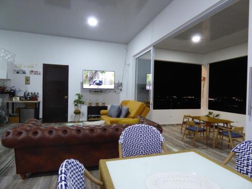 a living room with a couch and a table with chairs at Nido Acacias Cabaña espectacular Colibrí in Acacías