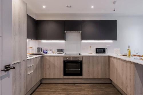 a kitchen with wooden cabinets and white counter tops at Little Sea - Moments from Waterfront Restaurants in Poole