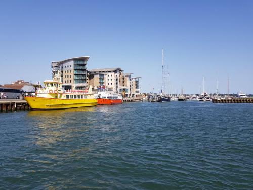 two boats are docked in a harbor with buildings at Little Sea - Moments from Waterfront Restaurants in Poole