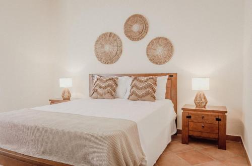 a bedroom with a white bed with two night stands at Casa dos Almargens - Moradia 3 quartos com piscina in São Brás de Alportel