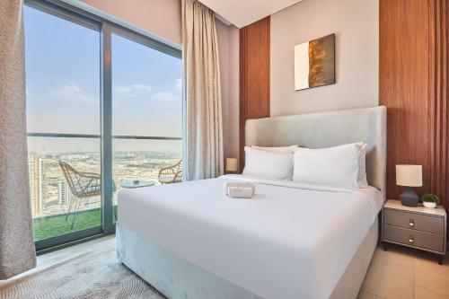 a bedroom with a large bed and a large window at STAY BY LATINEM Luxury 1BR Holiday Home W 2709 Near Burj Khalifa in Dubai