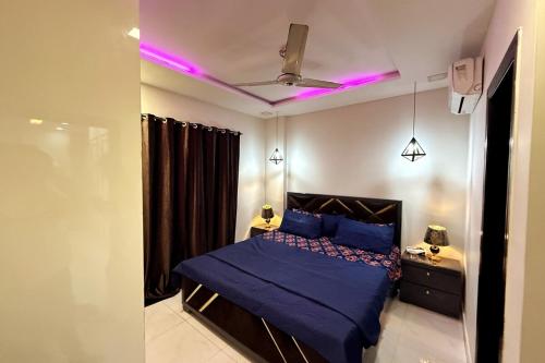 a bedroom with a blue bed with purple lights at Soundproof 2 Bed apartment in Lahore Zameen Opal in Lahore