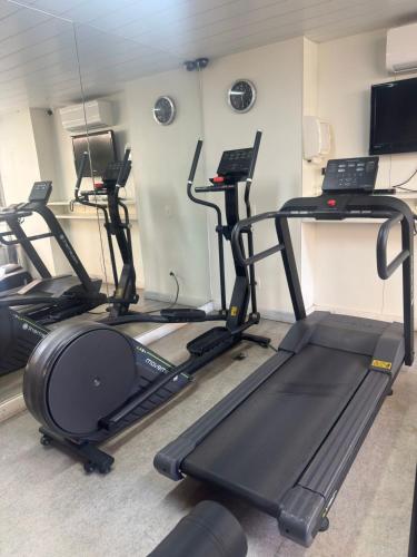 a gym with several tread machines in a room at Max Savassi Glamour in Belo Horizonte